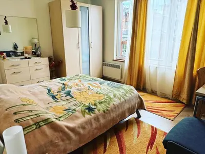 a bedroom with a bed with a flower blanket on it at Pirin Golf View Apartment Bansko in Bansko