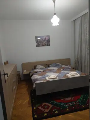 a bedroom with a bed and a dresser in it at апартамент У дома in Plovdiv