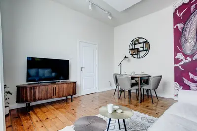 a living room with a tv and a table at Cozy Bright Space in the Heart of Women's Market in Sofia