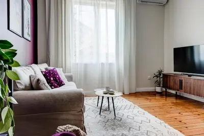 a living room with a couch and a flat screen tv at Cozy Bright Space in the Heart of Women's Market in Sofia