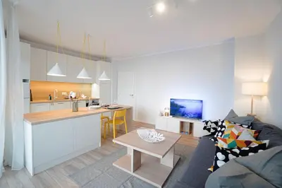 a living room and kitchen with a couch and a table at Scandinavian Airy APT in Business Area & Airport in Sofia