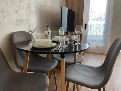 a black table with chairs and wine bottles on it at Comfort Airport Metro Suite in Sofia