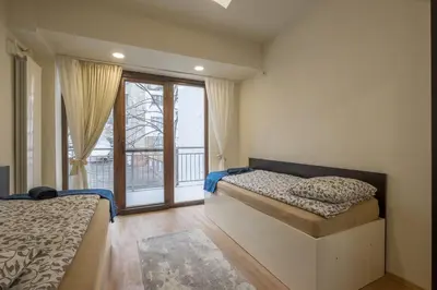 a bedroom with two beds and a large window at Stylish TOP center Flat 100m to Vitosha blvd in Sofia