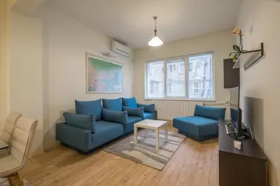 a living room with blue couches and a tv at Stylish TOP center Flat 100m to Vitosha blvd in Sofia