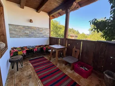 a screened in porch with a bench and a table at Вили Панорама Лещен in Leshten