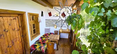 a room with a wooden table and a bench at Вили Панорама Лещен in Leshten