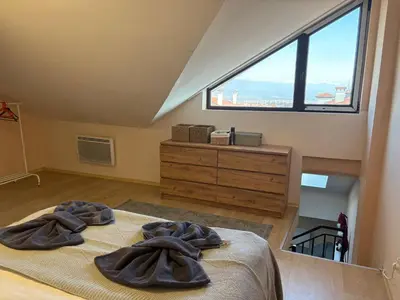 a bedroom with two robes on a bed with a window at Bansko Spomar in Bansko