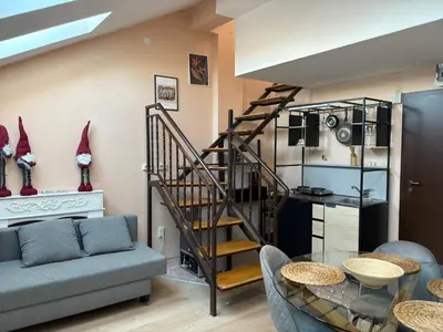 a living room with a spiral staircase and a table at Bansko Spomar in Bansko
