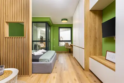 a bedroom with a bed and green walls at Bright & Cozy Studio in Plovdiv by Flat Mаnager in Plovdiv