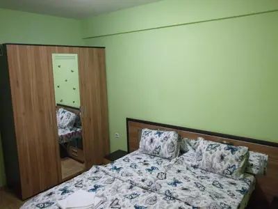 a bedroom with a bed and a mirror at Апартамент за гости 