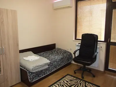 a room with a bed and a chair in it at Апартамент за гости 