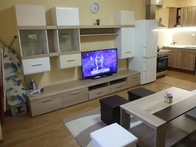 a living room with a tv on a entertainment center at Апартамент за гости 