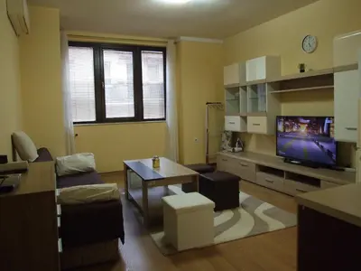 a living room with a couch and a tv at Апартамент за гости 