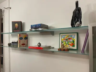 a shelf on a wall with books and a statue at Art city studio in Sofia center in Sofia