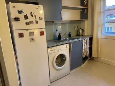 a kitchen with a refrigerator and a washing machine at Art city studio in Sofia center in Sofia