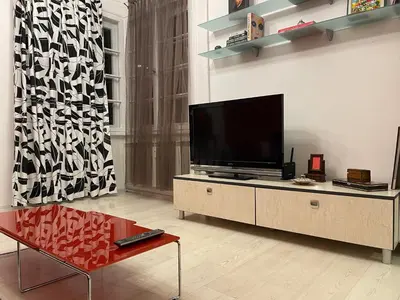 a living room with a flat screen tv on a cabinet at Art city studio in Sofia center in Sofia