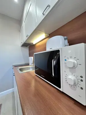 a microwave sitting on top of a counter in a kitchen at Elegance28 - Stylish Mountain Retreat in Bansko by Flat Mаnager in Bansko