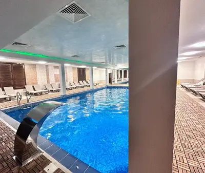 a large swimming pool with blue water in a building at Elegance28 - Stylish Mountain Retreat in Bansko by Flat Mаnager in Bansko