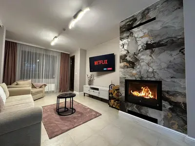 a living room with a fireplace and a couch at Elegance28 - Stylish Mountain Retreat in Bansko by Flat Mаnager in Bansko
