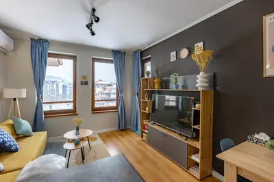 a living room with a couch and a tv at Modern 1 Bedroom by the Gondola in Bansko
