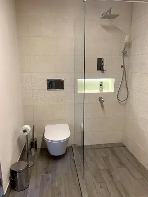 a bathroom with a toilet and a glass shower at Cozy townhouse in the heart of Sofia in Sofia