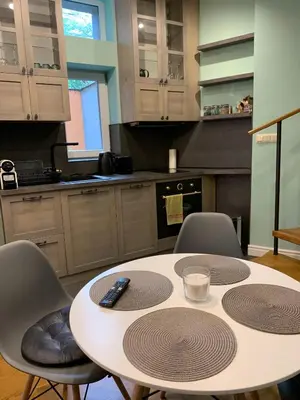 a kitchen with a table and chairs with a remote control on it at Cozy townhouse in the heart of Sofia in Sofia