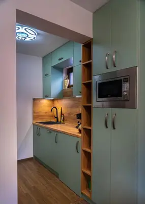 a kitchen with blue cabinets and a sink and a microwave at Next to Kapana - Art Apartment in Plovdiv