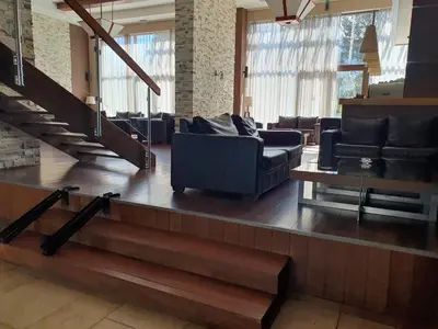 a living room with leather furniture and a staircase at AZAX Apartments in Terra Complex in Bansko