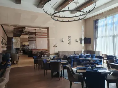 a dining room with tables and chairs and a chandelier at AZAX Apartments in Terra Complex in Bansko