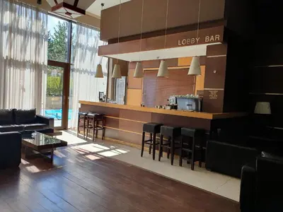 a lobby with a bar with chairs and a table at AZAX Apartments in Terra Complex in Bansko
