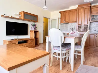 a kitchen with a table and chairs and a tv at Cite Jardin in Sofia