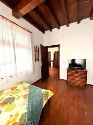 a bedroom with a bed and a dresser and a television at Nadejda Guest House in Tyzha in Tŭzha