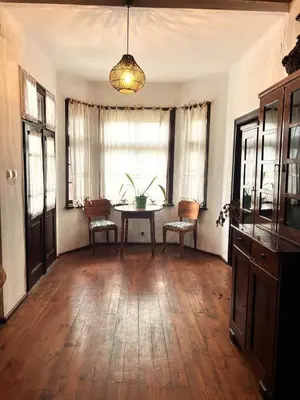 a living room with a table and chairs and a window at Nadejda Guest House in Tyzha in Tŭzha