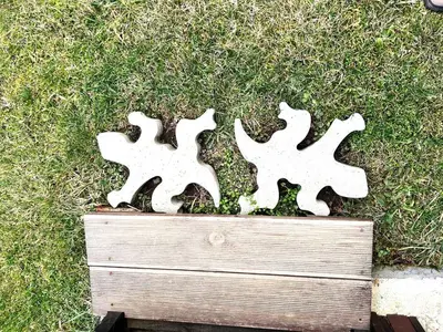 two pieces of white metal in the grass at Nadejda Guest House in Tyzha in Tŭzha