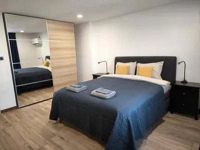 a bedroom with a bed and a large mirror at Victoria Elegance Apartment in Sofia