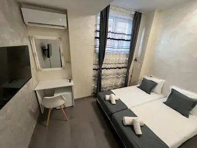 a bedroom with two beds and a desk and a mirror at BoxRoom2 in Kyustendil