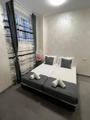 a bedroom with a large bed with two towels on it at BoxRoom2 in Kyustendil