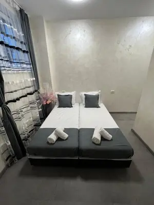 a bedroom with a bed with two slippers on it at BoxRoom2 in Kyustendil