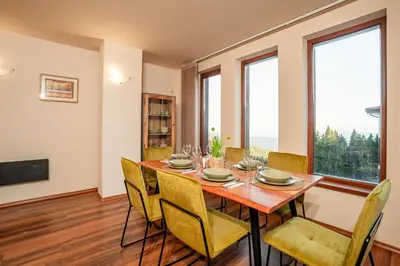 a dining room with a wooden table and chairs at GREEN STAR Grand Resort Pamporovo in Pamporovo