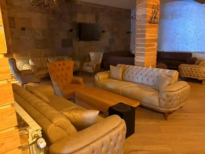 a living room with leather couches and a tv at GREEN STAR Grand Resort Pamporovo in Pamporovo