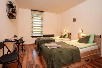 a bedroom with two beds and a window at GREEN STAR Grand Resort Pamporovo in Pamporovo