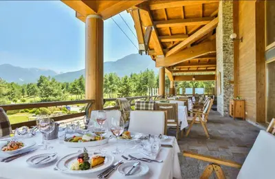 a dining room with a table with plates of food at Pirin Golf Resort & SPA Two-Bedroom Apartment in Razlog
