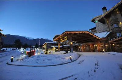 a snow covered yard in front of a lodge at Pirin Golf Resort & SPA Two-Bedroom Apartment in Razlog