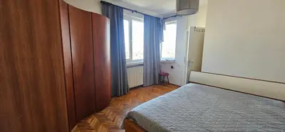 a bedroom with a bed and a large window at Home away from home in Sofia