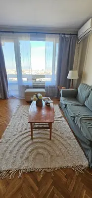 a living room with a coffee table in front of a bed at Home away from home in Sofia
