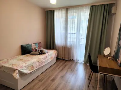 a bedroom with a bed and a large window at Prima apartment in Sofia