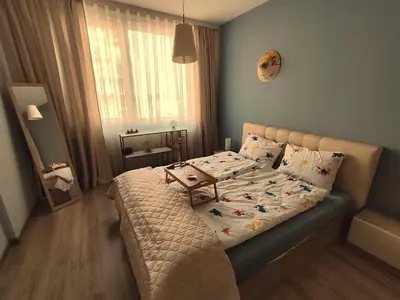a bedroom with a bed with a table on it at Prima apartment in Sofia