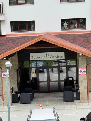 a front view of a building with a garage at Borovets Gardens MVS Apart D42 in Borovets