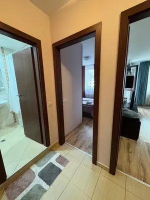 a living room with two glass doors and a rug at Borovets Gardens MVS Apart D42 in Borovets