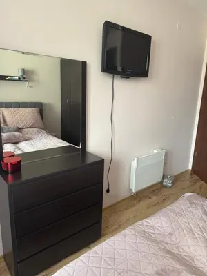 a bedroom with a bed and a tv on the wall at Borovets Gardens MVS Apart D42 in Borovets